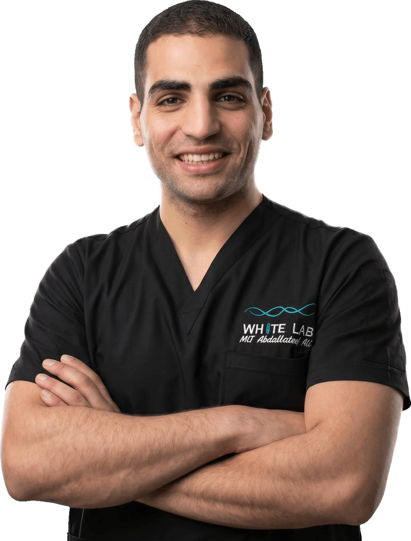 أخصائي المختبرات الطبية عبد اللطيف علي من فريق وايت لاب، بزيّ المختبر ومبتسماً