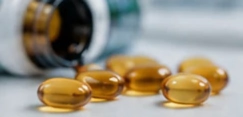 كبسولات فيتامين د بجانب علبتها